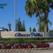 The Breezy Hill Sign with flowers blooming below it and a bright blue sky above it.