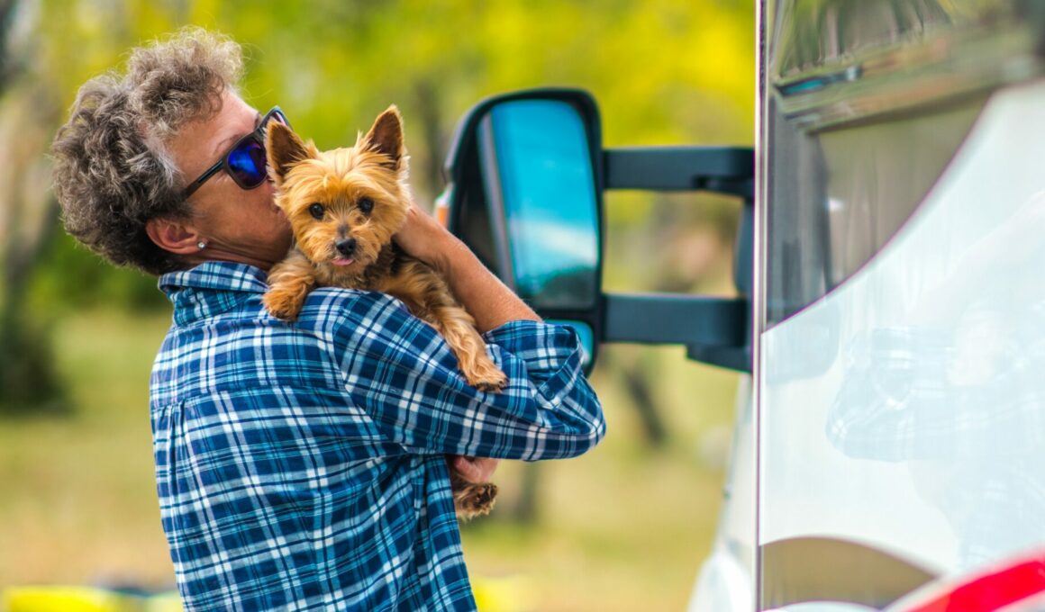 A person holding their Yorkshire Terrier as they stand outside their RV.