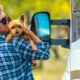 A person holding their Yorkshire Terrier as they stand outside their RV.