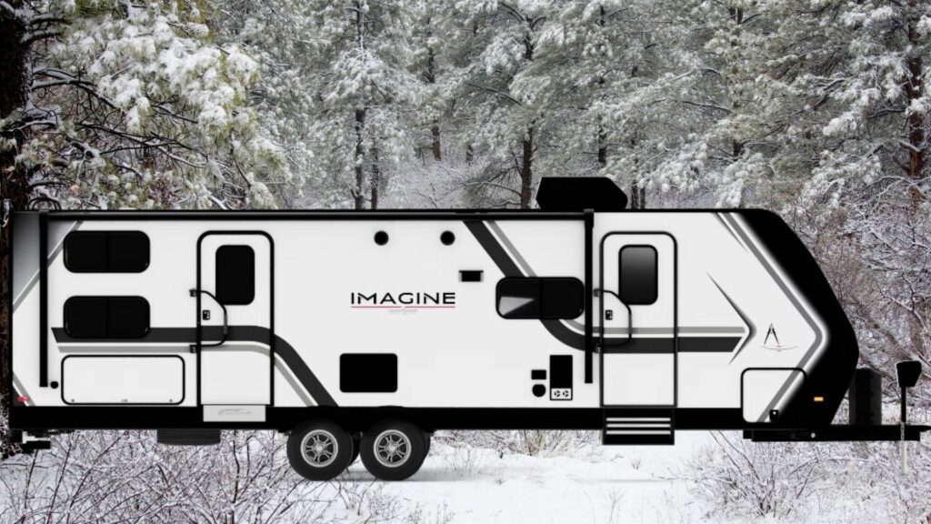 The Grand Design Imagine 3210BH travel trailer exterior with a snowy background. 