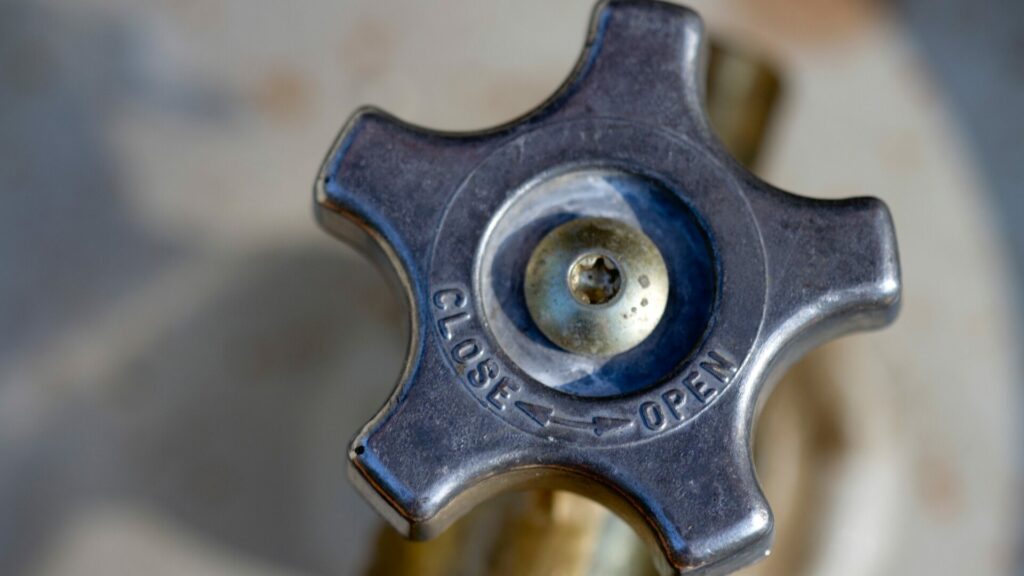 A close up shot of a black propane valve that states to turn left to close and to turn right to open. 