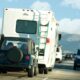 An RV towing a jeep behind it on a highway.