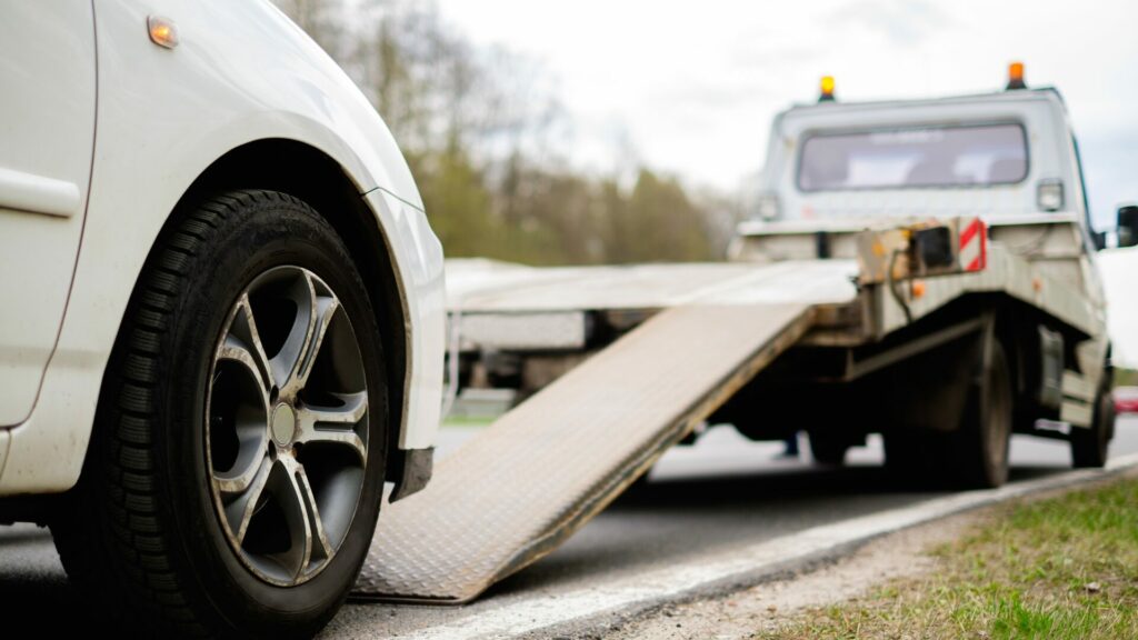 A car being put onto a tow truck close up. 