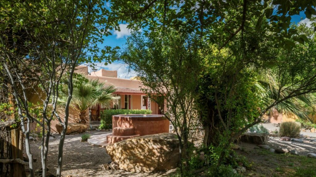 A photo of Ted Turner's Sierra Grande Retreat displaying the relaxing desert environment shrouded in trees. 