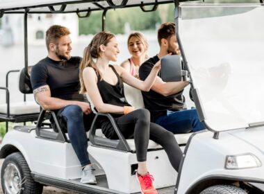 A group of people in a golf cart enjoying themselves.