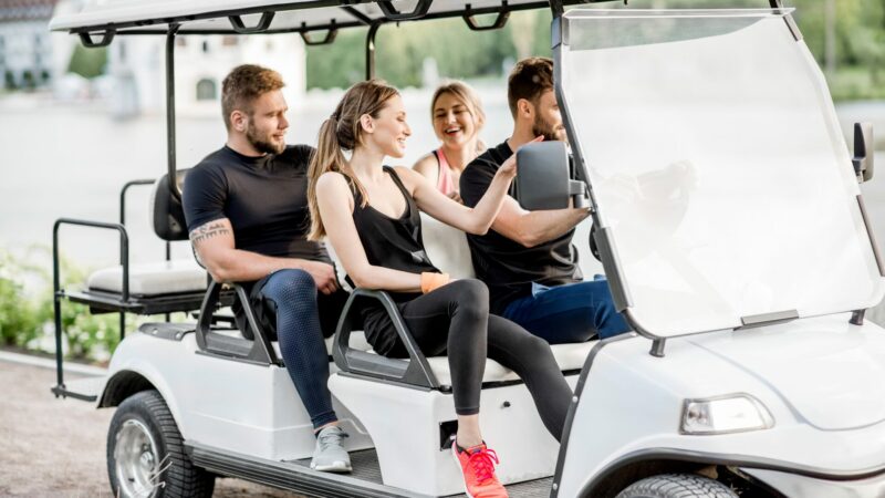 A group of people in a golf cart enjoying themselves.