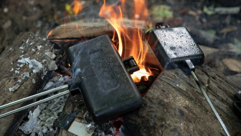 An up-close photo of two pie irons ina campfire.