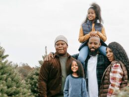 A family of five at a pine tree farm in the winter.