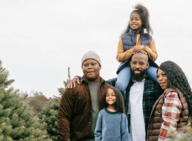 A family of five at a pine tree farm in the winter.