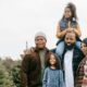 A family of five at a pine tree farm in the winter.