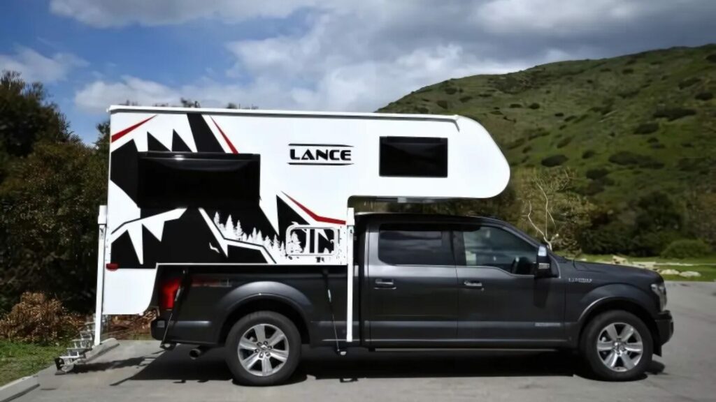 One of Lance's truck bed campers set up on a truck in a parking lot. 