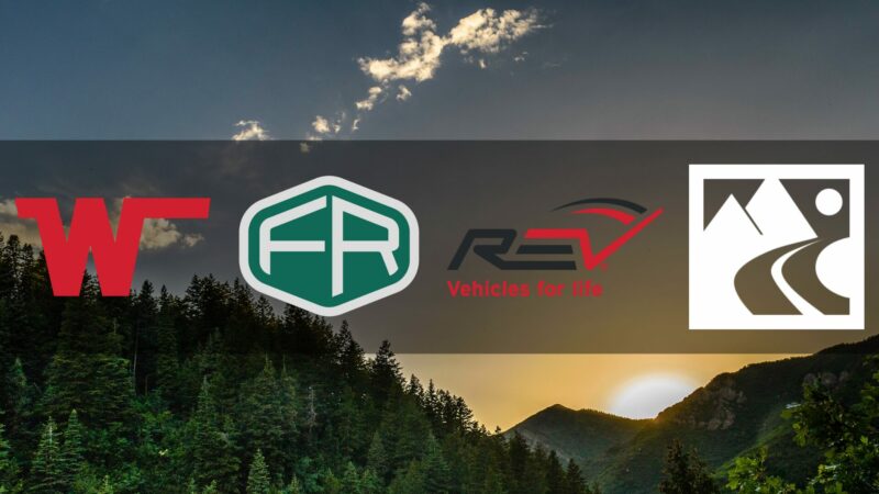 A background image depicting a setting sun over a densely forested ridge as four RV manufacturer logos overlay the image.